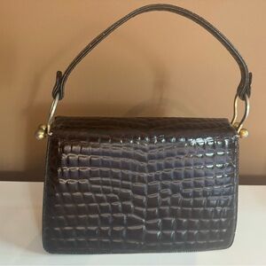 Vintage dark brown clutch purse. Embossed animal print with gold hardware.